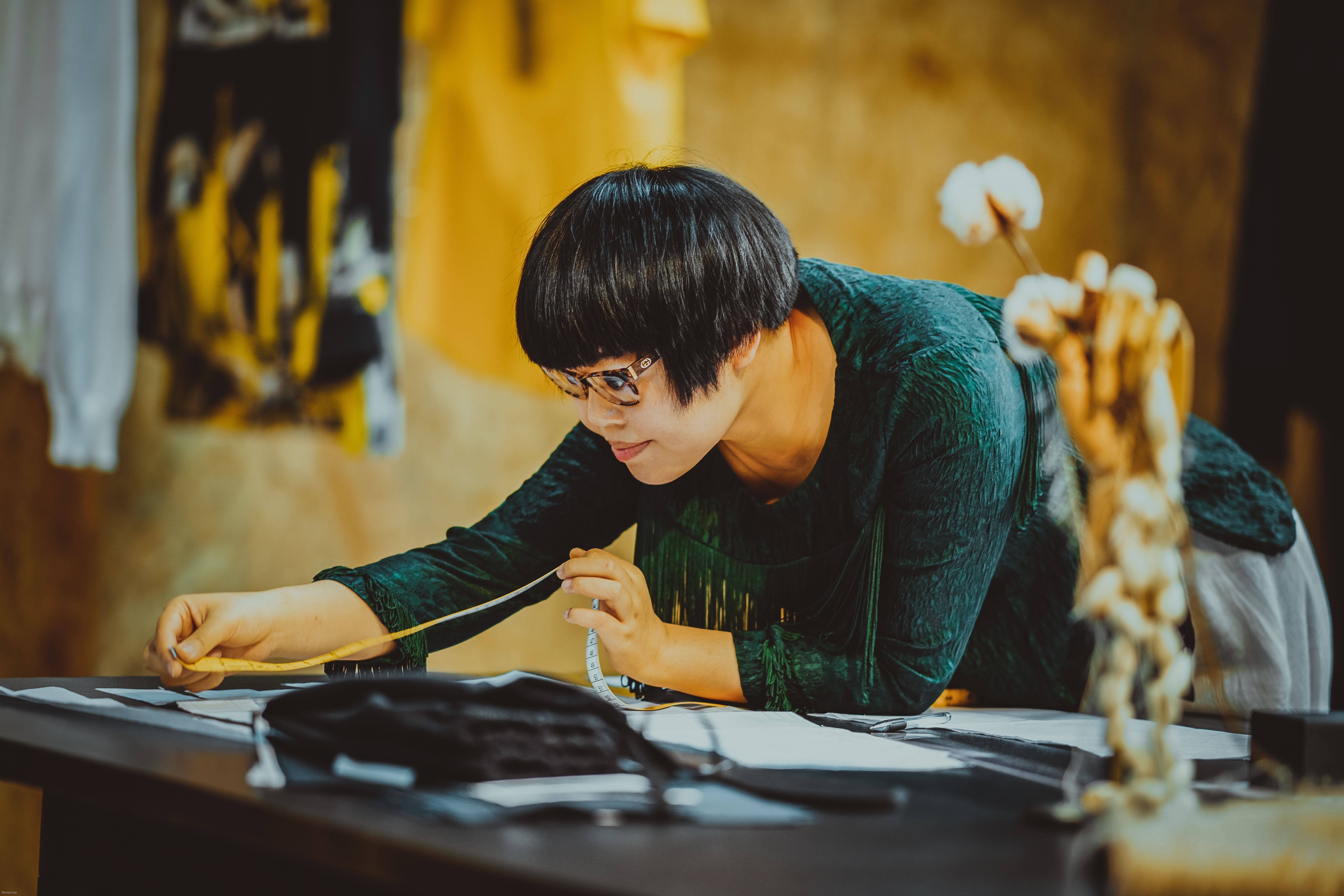 woman holding measuring tape leaning on table
